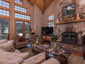 Great Room has soaring ceiling, fireplace and big windows for the beautiful view