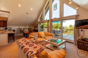 Living room and dining room with view out to front deck