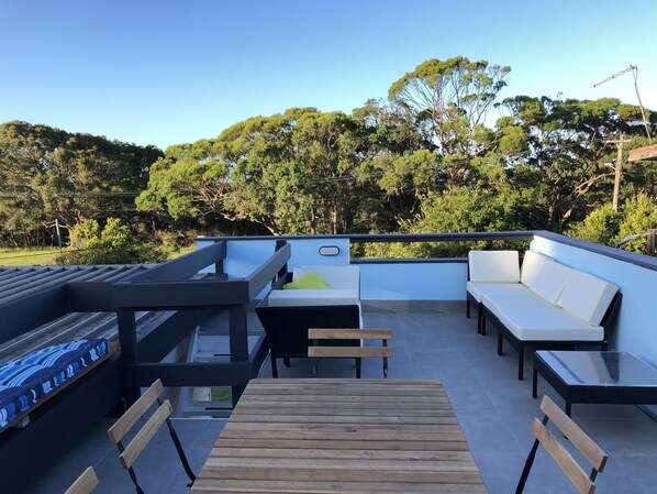 Rooftop terrace with river and bush reserve views. Lounges and diningtable for 8