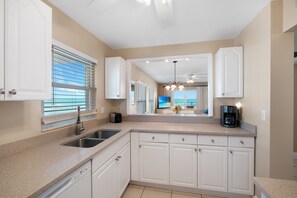 Cook with a view! This fully equipped kitchen offers stunning sights of both the sparkling pool and the serene ocean, making meal prep feel like a vacation itself