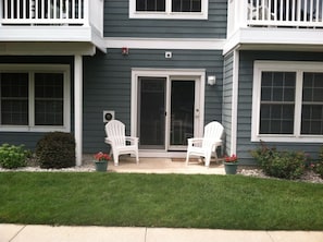 Patio and grass relaxation area with 2 stackable chairs