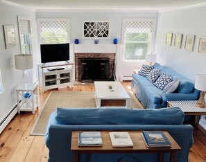 Living room with 4k HDR TV, DVD player, games, and books.