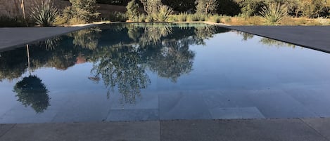 Une grande piscine carrelée avec deux plages