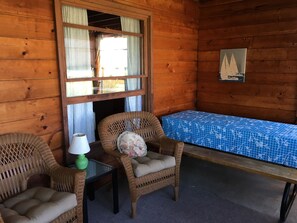 The Porch, with picnic table , 2 wicker chairs and a wicker sofa. 
