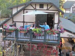 Couples enjoying a glass of wine on  2nd story private deck.  Flowers galore.