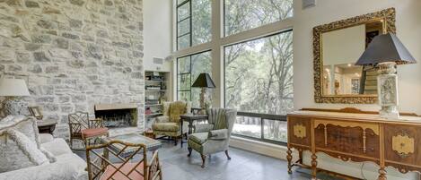 Formal living room with gas fireplace & large window views of treetops!