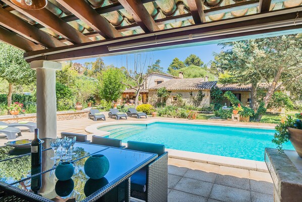 Vista de la piscina desde el porche del jardin.