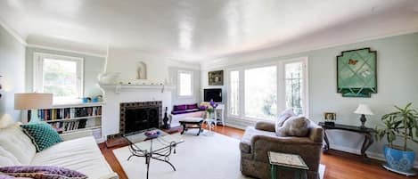 Sunny living room offers light from 3 sides, smart tv, working fireplace.