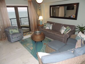 Living room with a wall of windows and a door to the lower balcony.