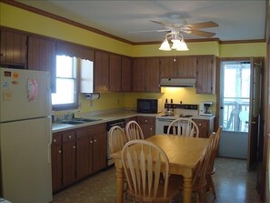 Fully-equipped kitchen leads to screened-in back porch