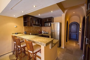 Fully stocked kitchen with granite counters and breakfast bar.