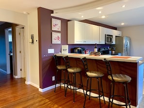 To the right, is the kitchen with a 4-person bar-top and fully-equipped kitchen.