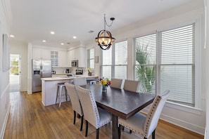 Modern dining room table with well stocked open concept kitchen.