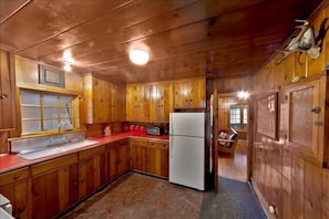 Kitchen, fully furnished with dishes, utensils, cookware and wine glasses. 