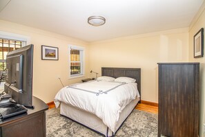Bedroom has queen bed, night stand, armoire, dresser and TV