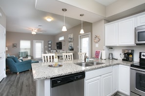 Fully appointed kitchen with granite counters and stainless steel appliances.