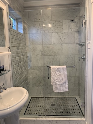 All natural stone tile shower with glass doors