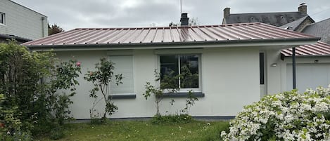 La maison en arrivant avec le jardin de devant et son abri vélo 