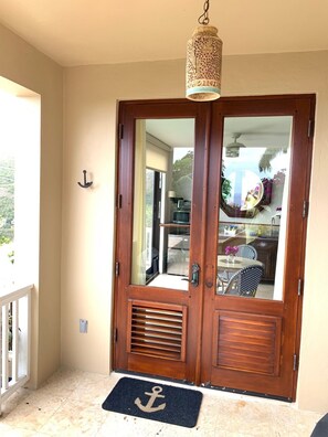 Private entry with custom mahogany french doors handmade Schnell pottery light.