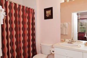 Master Bathroom with bath tub & shower,  wall mounted hair dryer and art works.