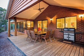 Step onto the breezy covered deck where a ceiling fan, gas BBQ, and an outdoor dining table for eight set the scene for relaxed lunches and sunset dinners under the gum trees.