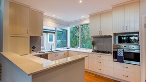 Channel your inner chef in the modern kitchen equipped with a gas cooktop, oven, and dishwasher.