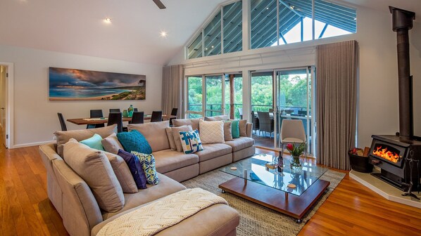 Sink into the expansive L-shaped sofa in the open-plan living area, watch your favourite TV shows or unwind by the wood-burning fireplace with a glass of local wine.​