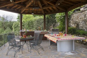 The summer kitchen is fully-equipped for poolside dining, with fridge and BBQ.