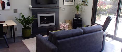 Living room with gas fireplace, sleeper sofa and   large flat screen TV.