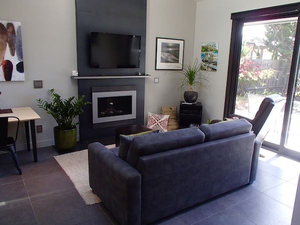 Living room with gas fireplace, sleeper sofa and   large flat screen TV.