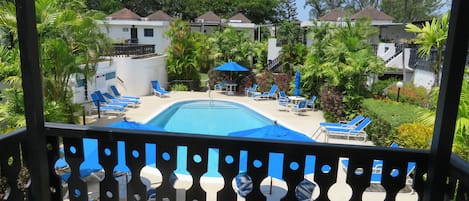 Large shaded balcony overlooking pool, ideal for relaxing or enjoying a meal