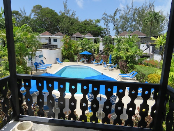 Large shaded balcony overlooking pool, ideal for relaxing or enjoying a meal