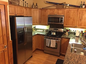 Well-appointed kitchen with granite counters, dishwasher, gas range
