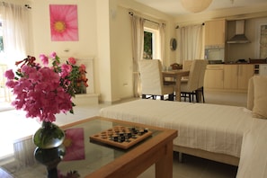 Living and dining area with 2 sets of double doors leading to patio and pool.