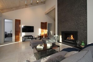 Living room with lit fireplace. The fireplace goes up 20 ft!