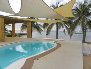 Pool , pergola on the left, sandy point beach area - top left between columns