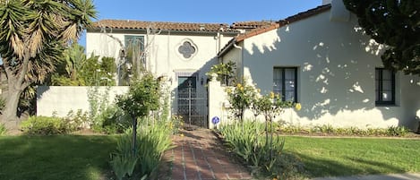 Entry is down an allée of rose bushes into a gated court...