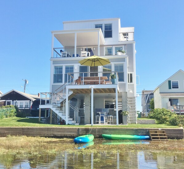 High tide. Small lawn area. Grill, bar/lounge under house. 3 of 4 decks shown.