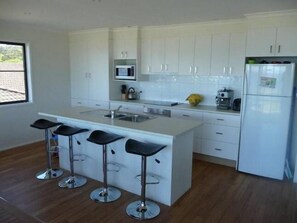 Open plan kitchen with dishwasher and coffee machine makes entertaining a breeze