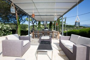 Pool-level sofas, gas barbecue and dining for 12 under the pergola. 