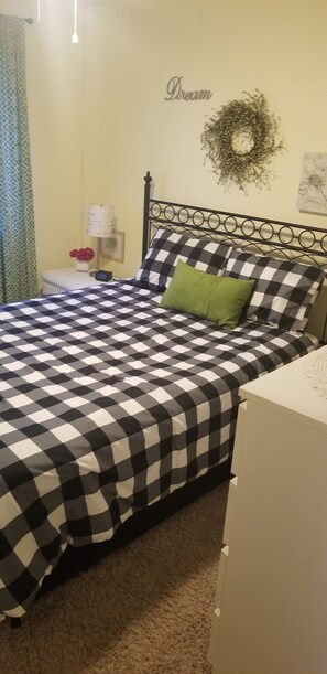 Main bedroom with queen bed, ceiling fan, TV  with Roku and dresser.