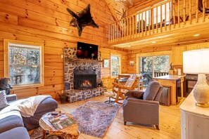 Large open living room with wood burning fireplace and wrap around decks,