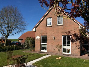 Greetsiel Landhaus Rolandseck, eingezäumter Garten und im Hintergrund der Deich