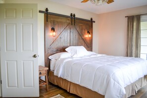 Bedroom 1 with king bed, quality linens and barn door headboard.
