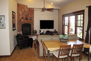 Living room with large flat screen TV and fireplace.