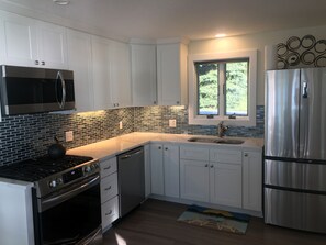 Modern kitchen with quartz counters and full size stainless appliances
