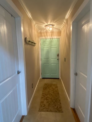 Entryway shows all new trim work, interior doors, lighting, and updated decor. 