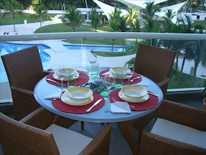 A comfortable balcony has a beautiful eating area and two recliners