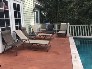Pool deck with chairs, end tables and lounge chairs