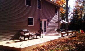 Back deck with sitting area, outdoor table, and bench seating